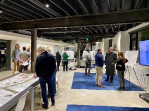Open house attendees review project boards.